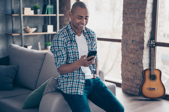 Portrait of positive charming cheerful millennial hold hand modern technology read free time vacation news stand room apartment checked shirt denim jeans plaid - Powered by Adobe