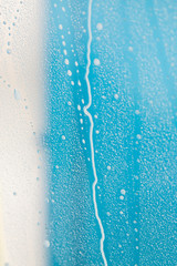 Blauer Hintergrund mit Wassertropfen auf Scheibe