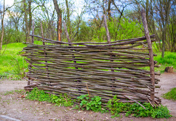 View of wattle hurdle – construction, made of thin tree branches – in a spring park.