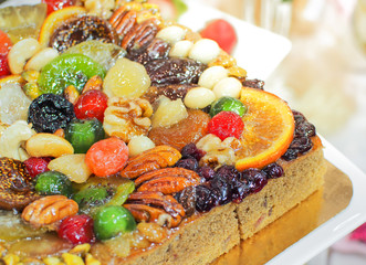 Sweet desserts with sweet fruits and nuts topping. Fruit Tart  or Fruit cake delicious sponge cake closeup.