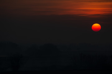 Abstract composition of the sun at sunset and Windmill in front of the sun