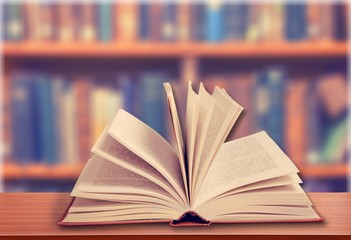 Open old books in the library on wooden desk
