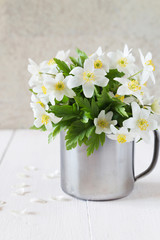 Bunch of white spring flowers in an iron mug