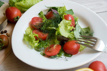 Vegetable salad with fresh lettuce, tomatoes and cucumber in clay pot. Top view.