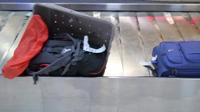 4k Baggage Claim in international airport. People picking up paper box and Bags from conveyor belt at Thailand. Luggage travels on a conveyor belt