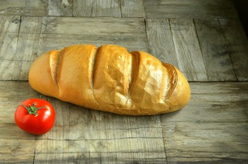 bread and tomato on wooden background