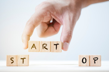 Human hand array Start and stop keyword on wooden cubic. This is wording conceptual create symbol...