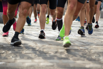 Fototapeta premium Legs of people running on the street, front view