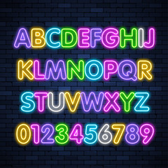 Glowing neon multicolored alphabet on brick wall background