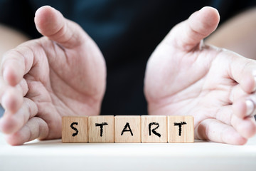 2 Hand push start keyword on wooden cubics. It is begin of positive mindset.