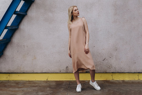 Stylish And Cool Woman Dressed In A Long Dress Posing Against Street , Urban Clothing Style. Street Photography, Copy Space