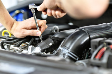car mechanic in a workshop - closeup engine repair and diagnosis on a vehicle