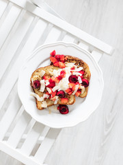 French toast with berries and mascarpone cheese on a light background.