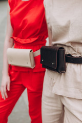 a cropped photo of a waist bag that is fixed to the girls at the waist, urban clothing style. Street photography