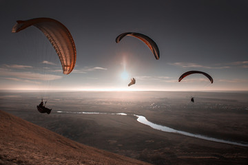 Paraglide with a paraglider in a cocoon against the background of fields of the sky and clouds....
