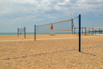 Beach volleyball. Volleyball court on the beach. Lifeguard cabin on the beach. The concept of active, sports summer holiday.