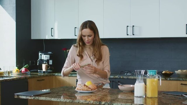 Happy woman making photo at mobile phone. Cheerful woman taking food photo