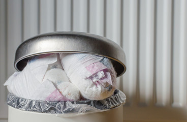 Trash bin full of used diapers. Close up.
