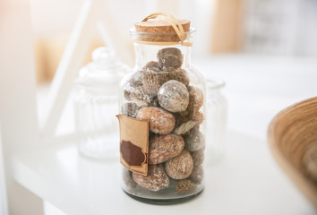 Home details decorations lying on the shelf. Wooden background. Loft style. Cosy rustic mood. Nuts in the jar. Straw basket.