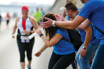 Fans group cheering up a marathon runner