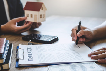 Estate agent giving house and keys to client after signing agreement contract real estate with approved mortgage application form, concerning mortgage loan offer for and house insurance