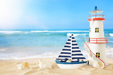 vintage wooden boat and lighthouse over beach sand and sea landscape background