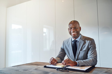 Smiling African American businessman sitting with paperwork in a