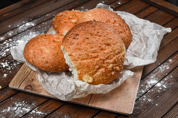 tasty bread on white paper on brown wooden board