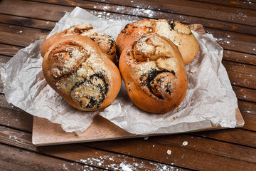 tasty bread on white paper on brown wooden board