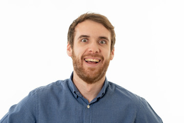 Obraz premium Happy young attractive man shocked with a surprised funny face. Human expressions and emotions.