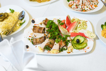 table served with delicious food. cooked salad, meat, stuffed crab sticks.