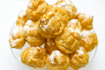a mountain of fresh eclairs with cream. powdered sugar cake.