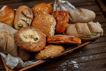 tasty bread on white paper on brown wooden board