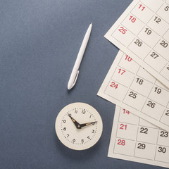 Fototapeta na wymiar Calendar with dates, clock and pen 