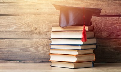 Graduation hat and stacks of books