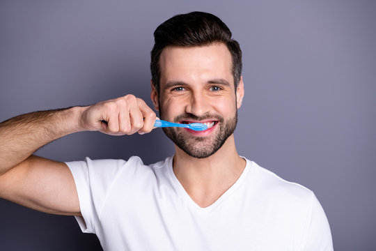Close up photo amazing he him his macho cleaning mouth buy buyer new hand novelty plastic personal equipment tooth brush shower prepare working day wear casual white t-shirt isolated grey background
