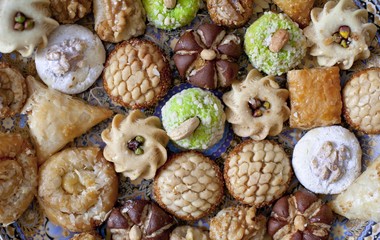 Oriental tea tray and cookies symbolising Moroccan hospitality, Islamic holidays food with decoration. Ramadan kareem. Eid mubarak. Oriental hospitality concept. Tea glasses and pot, traditional delig