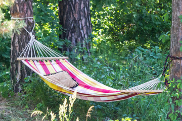 Summer camping. Cloth hammock. Sleeper in nature. Rest and life in the country. Green tourism. Daytime sleep in the fresh air. Travel goods. Vacationing outdoors.