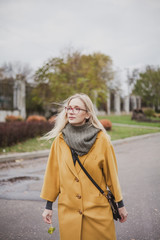 Cute blonde is walking in autumn park