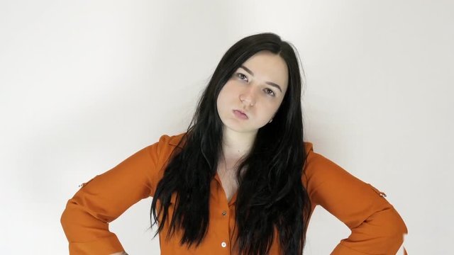 A young woman shows her displeasure and rage. She portrays emotions. Light background