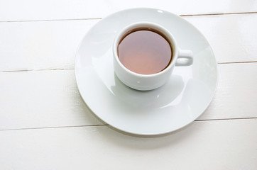 white cup of tea in a white plate on a white background