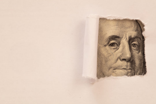 Benjamin Franklin Macro Peeking Through Torn White Paper