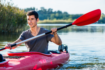 Man sitting in kayak paddling on lake