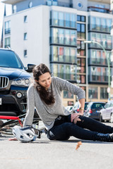 Injured woman with severe pain caused by knee sprain after bicycle accident
