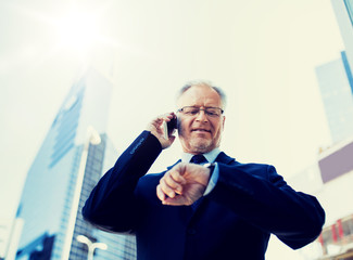 business, technology, time, punctuality and people concept - senior businessman calling on...