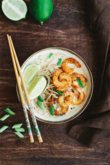 Coconut curry soup with noodles and shrimps in bowl. Asian cuisine concept