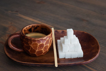 Sugar addiction concept shot of custom made clay espresso mug standing on oval plate with an...