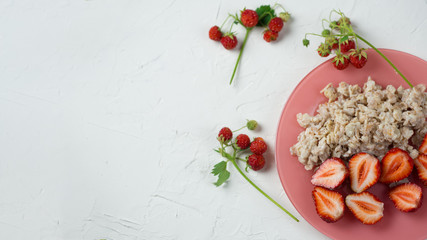 Oatmeal with strawberries on a white table . Healthy and tasty Breakfast