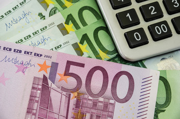banknotes of 100, 500 euros and a calculator, close-up.