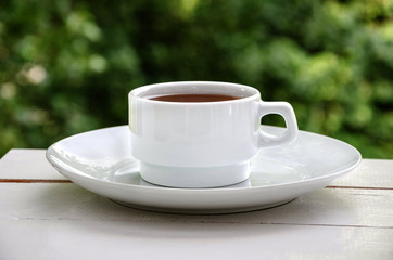 white cup of tea on a white table, close up